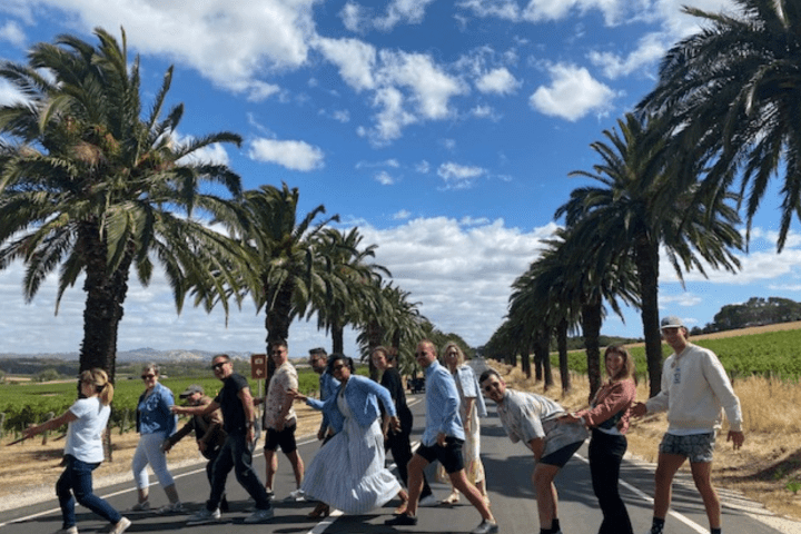 a group of people standing next to a palm tree