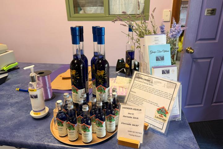 Display of lavender liqueur bottles and informational pamphlets on a counter.