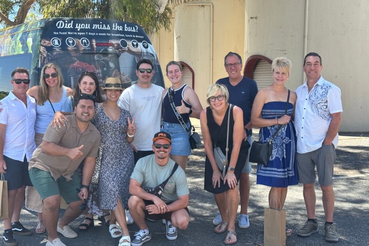 Group of people smiling in front of a bus with text 'Did you miss the bus?'