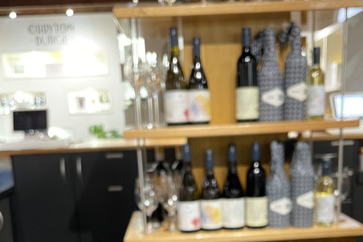 Close-up of 'Underground Barossa' menu and wine bottles on shelf in background.