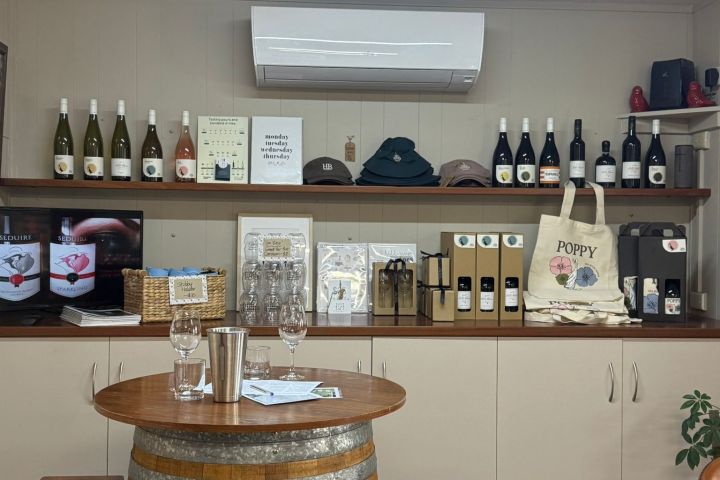 A wine tasting room with bottles, glasses, and a barrel table.