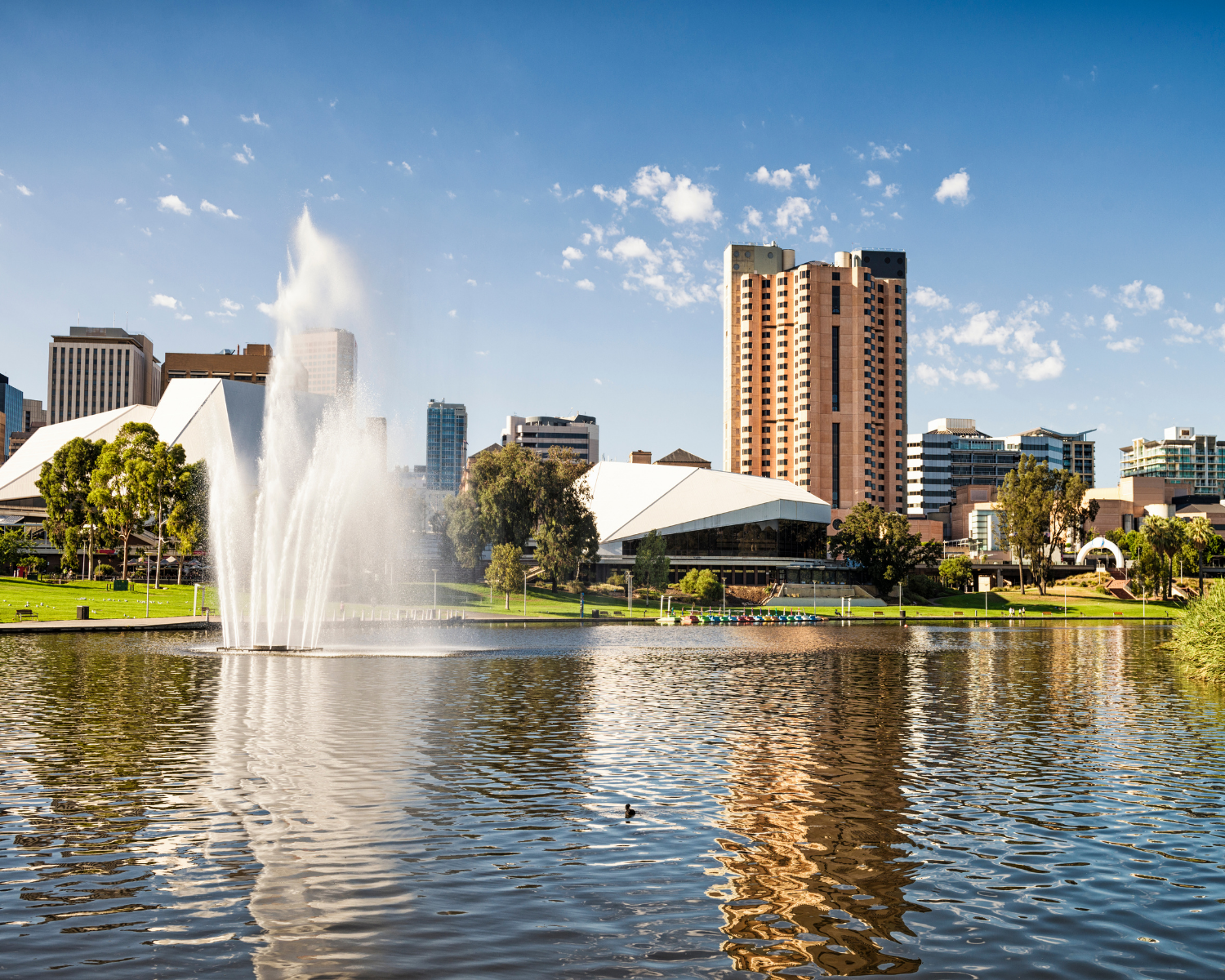 adelaide a fountain in front of a body of water