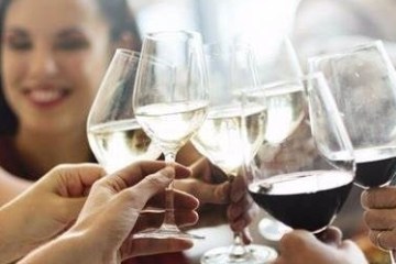 a woman sitting at a table with wine glasses