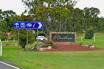 a blue sign in the middle of a field