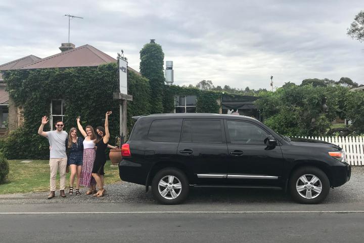 a group of people walking down a street next to a car