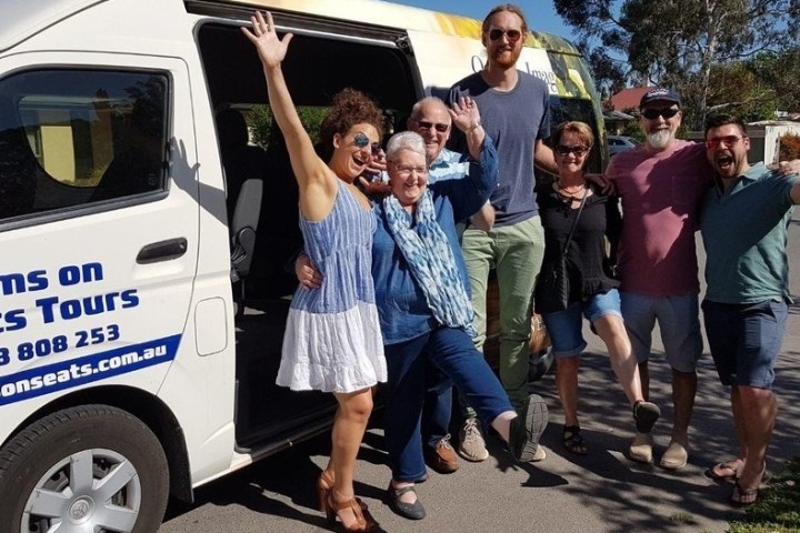 a group of people standing in front of a car posing for the camera
