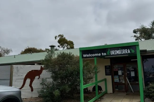 Building entrance with a kangaroo sign and 'Welcome to Urimbirra' sign.